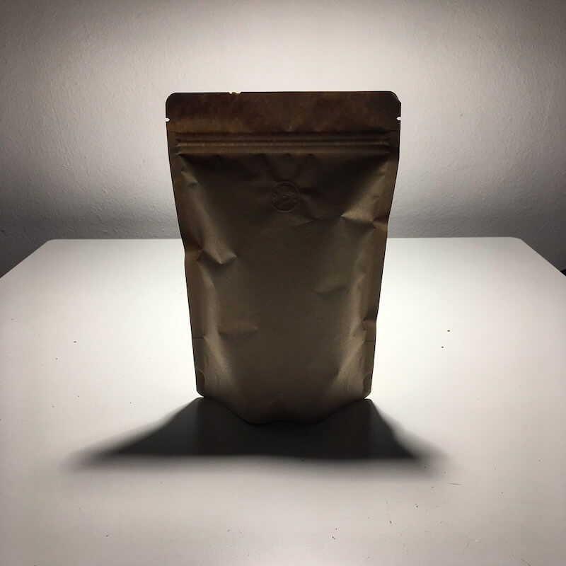 Plain coffee bag on a flat surface, simple product shot with minimal styling.