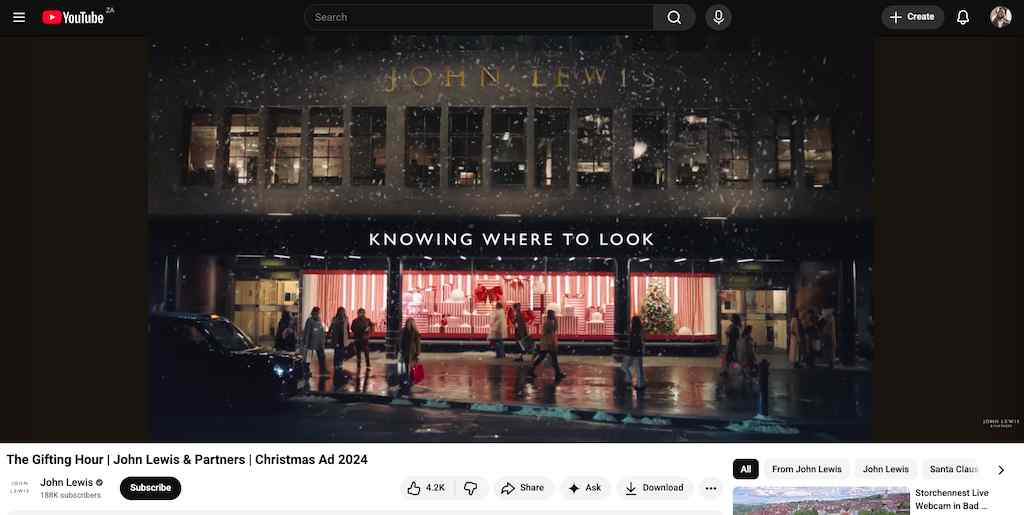A screenshot of a YouTube video showing a lit storefront window during a snowy night.
